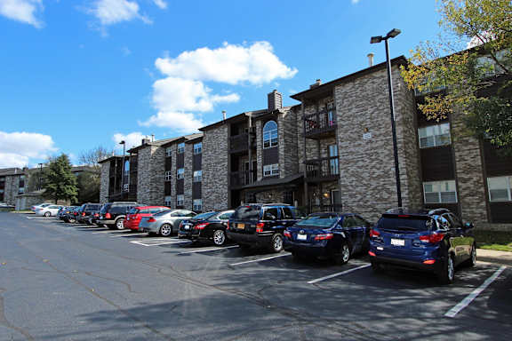 A parking lot with cars parked in front of a building.