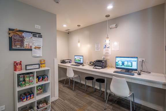 A small office with a white desk and two chairs.