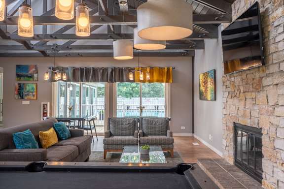 A living room with a fireplace and a pool table.