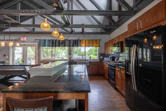 A kitchen with a black granite countertop and wooden cabinets.