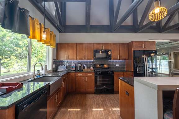 A kitchen with wooden cabinets and black appliances.