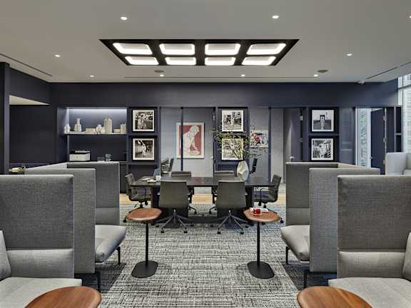 A modern office space with grey chairs and a carpeted floor.