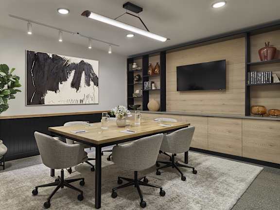 A conference room with a large table and chairs.