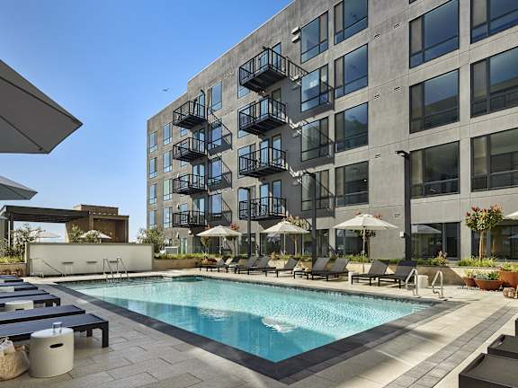 A large building with a pool in front of it.