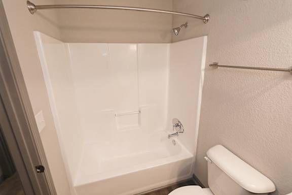 A white bathroom with a toilet and a bathtub.