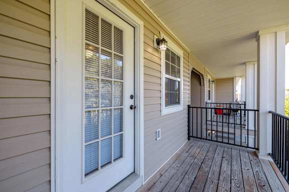 the front porch of a house with a black railing at Sterlington Apartments, Grovetown, GA