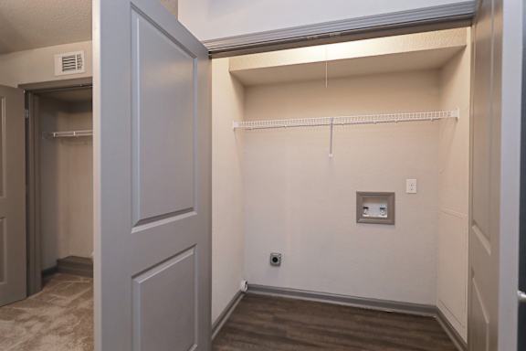 A small, empty room with a door and a shelf.