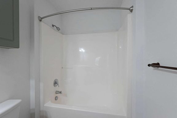 a white bathroom with a shower and a toilet at Sterlington Apartments, Georgia