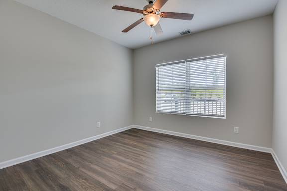 Bedroom with ceiling fan and window at The Vista Apartments &amp; Townhomes, Warrenville, South Carolina
