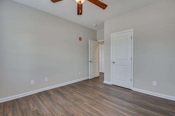 Bedroom with closet door and ceiling fan at The Vista Apartments &amp; Townhomes, Warrenville