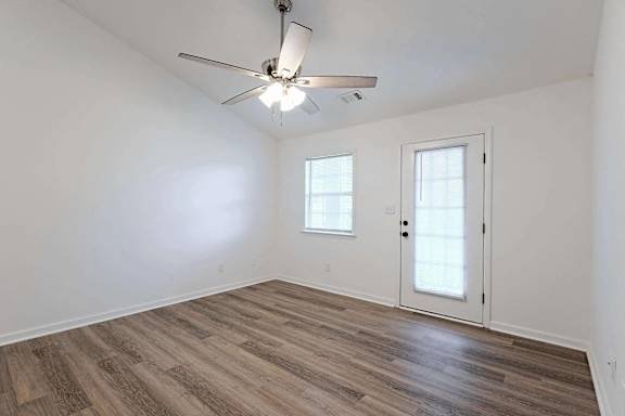 a living room with white walls and a ceiling fan    and a door at Sterlington Apartments, Grovetown, GA, 30813