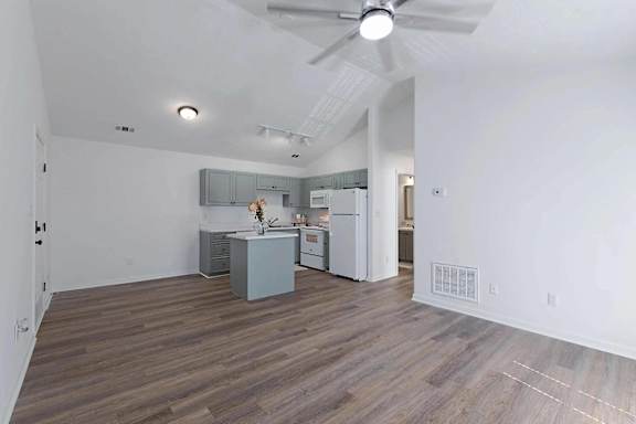 an empty living room with a kitchen and a ceiling fan at Sterlington Apartments, Grovetown, GA