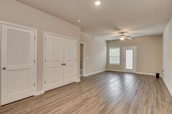 Living area with wood-like flooring and ceiling fan at Barrington Apartments, Greenwood, SC, 29649