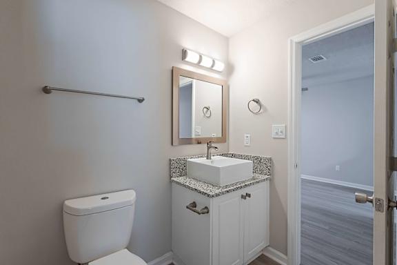 White sink and toilet and mirror at Sanctuary Apartments and Townhomes, Georgia, 30909