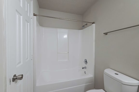 Bathtub with curtain and toilet at Sanctuary Apartments and Townhomes, Georgia