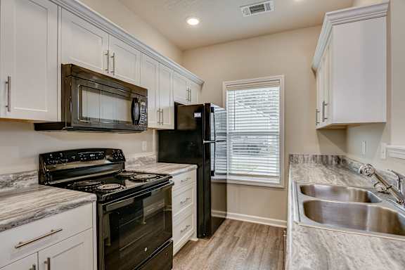 Kitchen with white cabinets and black appliances at Barrington Apartments, Greenwood, South Carolina