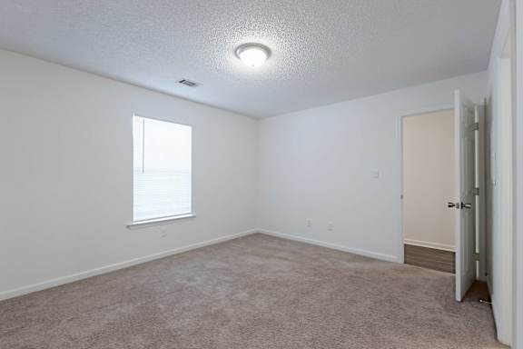 room with a carpeted floor and a window at Sanctuary Apartments and Townhomes, Augusta, GA 30909