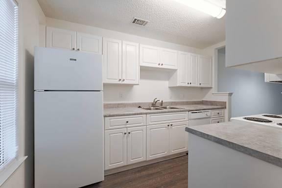 Practical clean kitchen with granite counter and fridge at Sanctuary Apartments and Townhomes, Georgia, 30909
