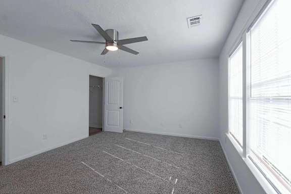 an empty living room with a ceiling fan and a window at Sterlington Apartments, Grovetown