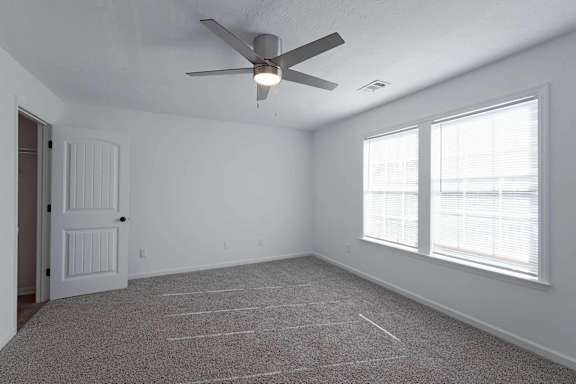 an empty bedroom with a ceiling fan and a window at Sterlington Apartments, Georgia, 30813