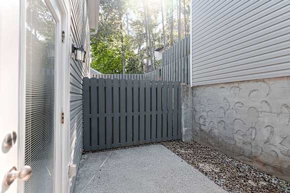 A grey fence is in front of a house.