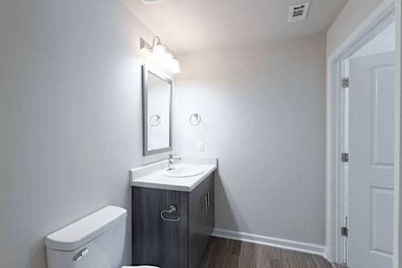 bathroom with a toilet and door at The Vista Apartments &amp; Townhomes, Warrenville