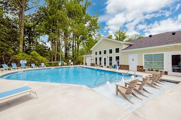 A pool with a blue bench and a building in the background at Helena Springs, Georgia