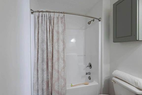 a bathroom with a shower and a toilet and a shower curtain at Sterlington Apartments, Grovetown, GA