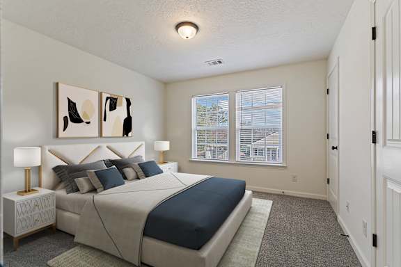 A bedroom with a large bed and two lamps.