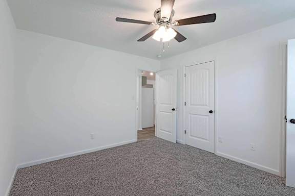 a living room with a ceiling fan and a door to a closet at Sterlington Apartments, Georgia, 30813