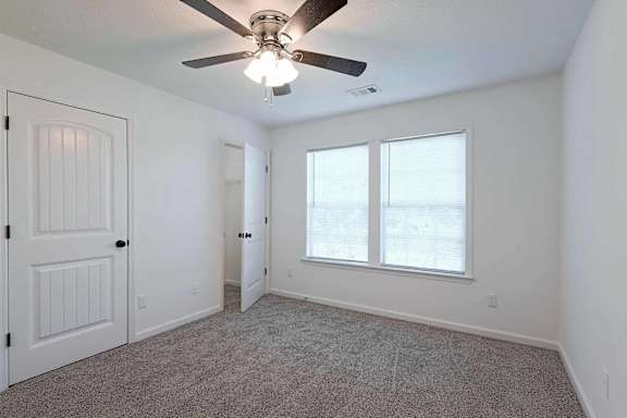 an empty bedroom with a ceiling fan and a window at Sterlington Apartments, Grovetown, Georgia