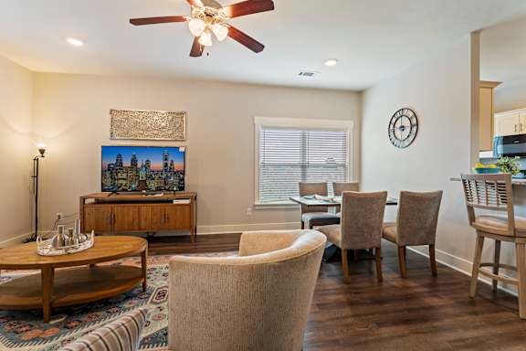 A living room with a television, a coffee table, and a rug.