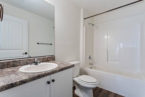 A white bathroom with a sink, toilet, and bathtub.