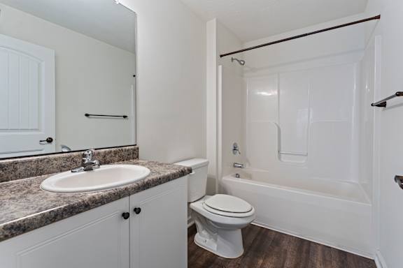 A white bathroom with a sink, toilet, and bathtub.