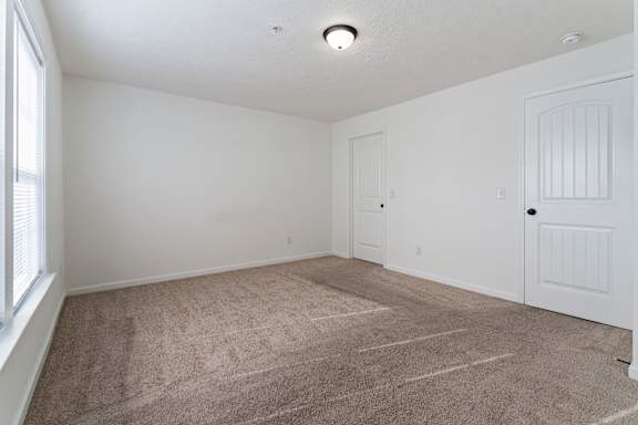 A room with white walls and a carpeted floor.