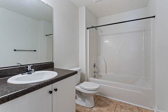A white toilet sits next to a sink in a bathroom.