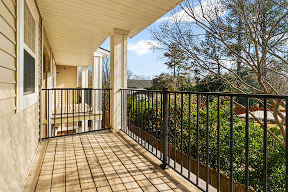 A balcony with a black railing and a tiled floor.