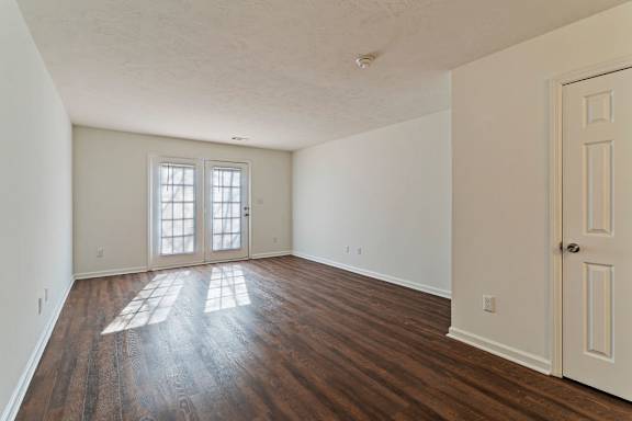 A room with a wooden floor and a white door.