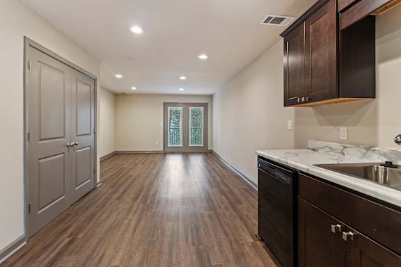 A kitchen with dark wood floors and a white counter top.