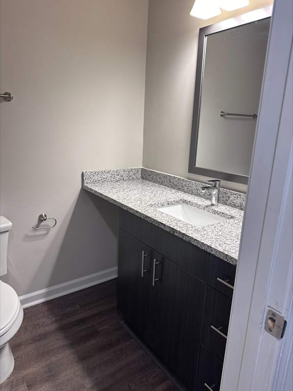 A bathroom with a sink, toilet and mirror.