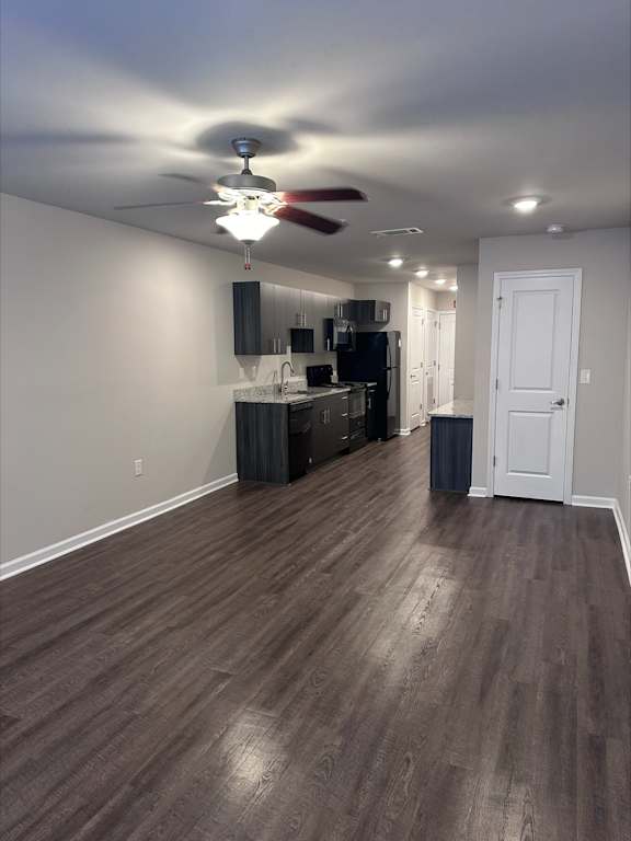 A room with a ceiling fan and wooden flooring.