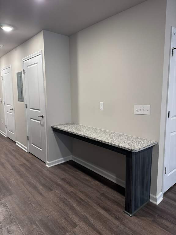 A long hallway with a bench and doors on the side.