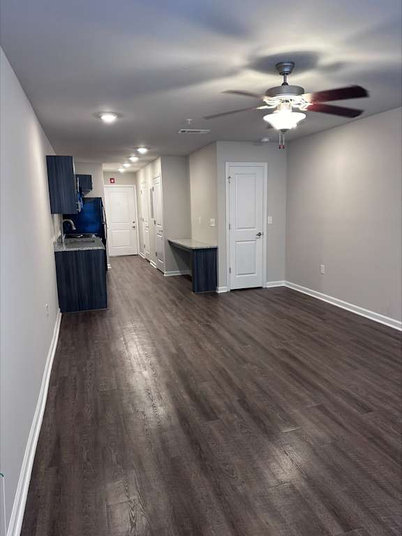 A room with a ceiling fan and wooden flooring.