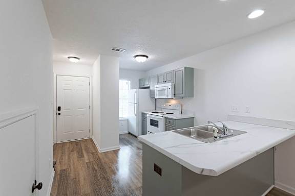 Kitchen area with white appliances and hallway leading to front door at Sterlington Apartments, Grovetown, GA, 30813