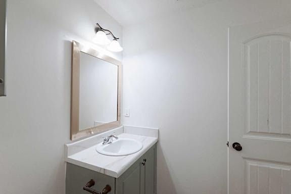 Bathroom with framed mirror and vanity lighting at Sterlington Apartments, Grovetown, Georgia
