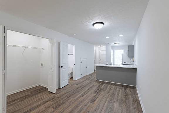 Living room with view of kitchen and washer/dryer closet at Sterlington Apartments, Grovetown