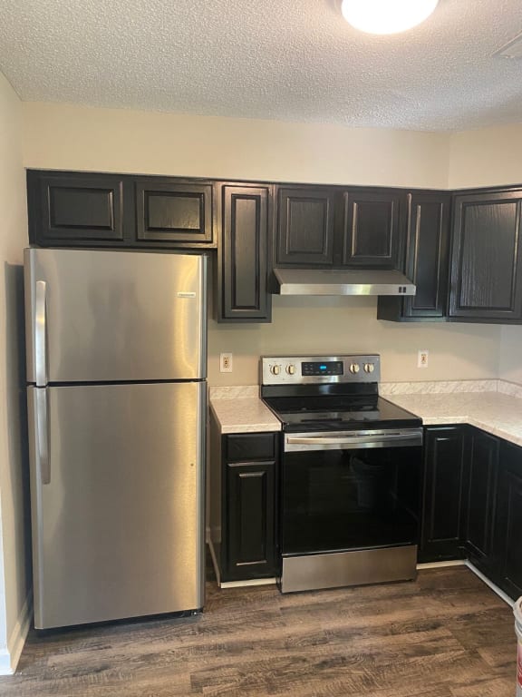 A kitchen with black cabinets and a stainless steel refrigerator at Diamond Townhomes, Beaufort, South Carolina
