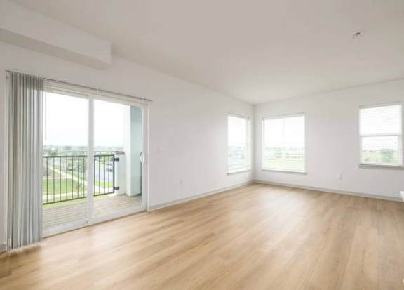 A large, empty room with wooden floors and white walls.