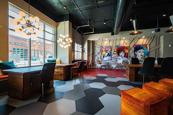 A room with a black and white checkered floor and a mural on the wall. at The Collective NoDa, Charlotte