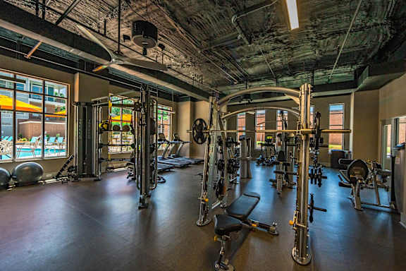 A gym with a variety of equipment including treadmills, weights, and exercise machines at The Collective NoDa, Charlotte